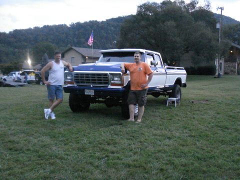 1994 Ford F-350 - A lifted Ford F-Series truck is parked on grass with two men standing next to it.