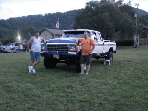 1994 Ford F-350 - Two men pose with a lifted Ford F-Series truck at an outdoor event.