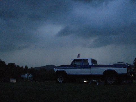 1994 Ford F-350 - Pickup truck with an American flag on the roof parked in a grassy field.