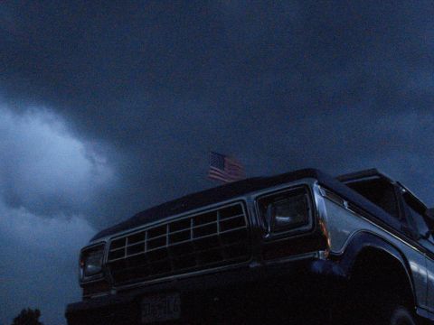 1994 Ford F-350 - Truck with American flag against a stormy sky.