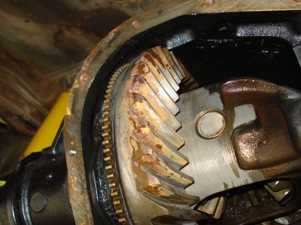 Close-up of rusty differential ring gear and pinion gear inside a differential housing
