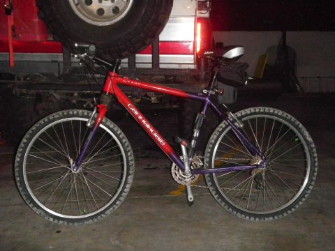 1991 Ford Bronco - Cannondale mountain bike parked in front of a vehicle with a spare tire mounted.