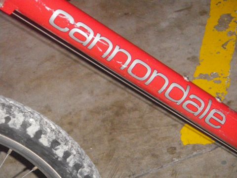 1991 Ford Bronco - Close-up of a red bicycle frame showing the Cannondale brand name and part of a tire.