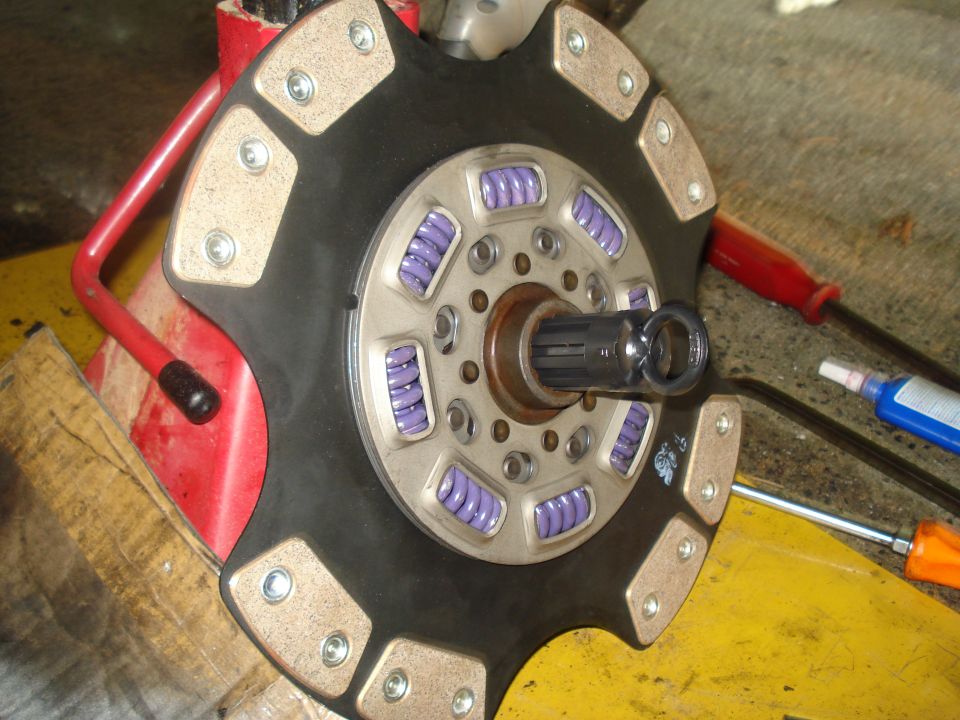 Clutch disc with purple springs and friction material, mounted on a splined shaft