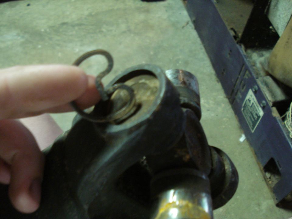 Close-up of a universal joint with a cotter pin being held by a finger