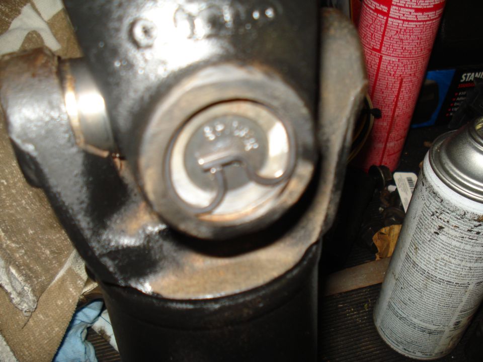 Close-up of a driveshaft universal joint with a U-joint strap and bolt visible