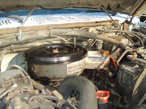 1984 Ford F-250 - Close-up view of the engine bay of a 1984 Ford F-250, showing the air filter assembly and various engine components.