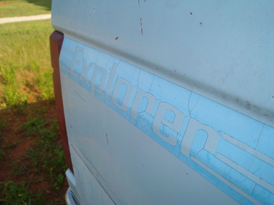 Side view of a truck with a faded "Explorer" decal on the body