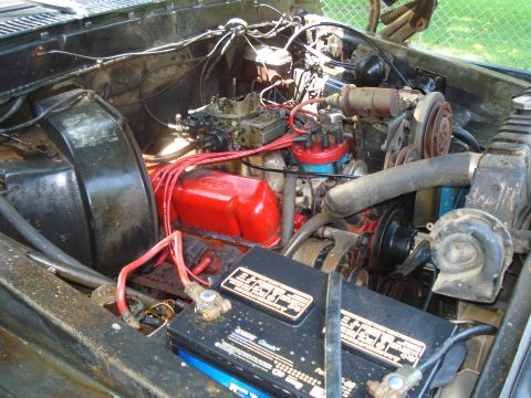 1984 Ford F-250 - Close-up of an engine bay with a V8 engine, battery, and various engine components visible.