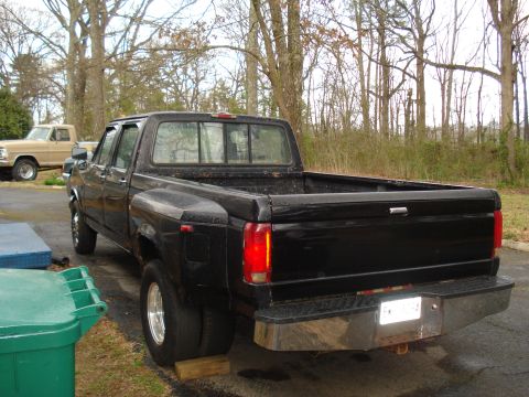 1994 Ford F-350 - A black dually pickup truck is parked outside, with another truck in the background.