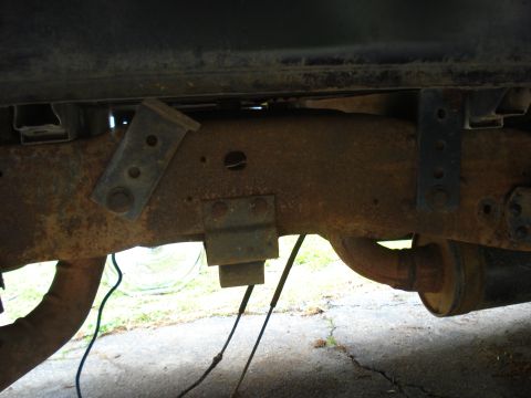 1994 Ford F-350 - Underside view of a heavily rusted truck frame, showing suspension parts and exhaust system.
