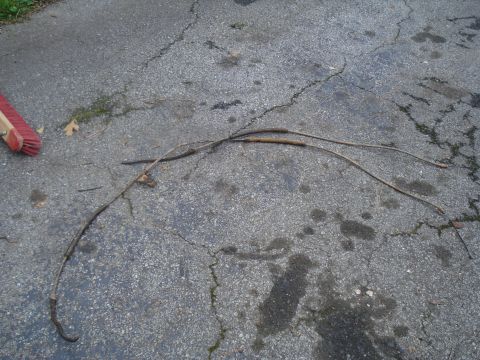 1994 Ford F-350 - These brake cables are laid out on a cracked asphalt surface, with a broom head nearby.