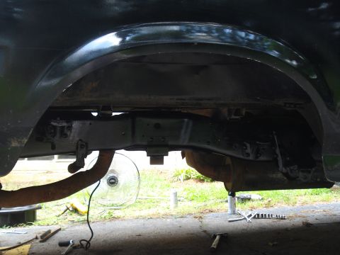 1994 Ford F-350 - Undercarriage view of a black truck, with a fan positioned near the exhaust pipe.