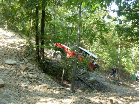 1983 Ford Bronco - 1983 Ford Bronco navigating a challenging off-road course in a wooded area.