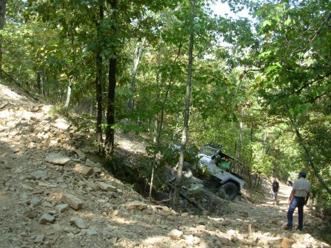 1983 Ford Bronco - Off-road vehicles tackle a challenging rocky trail in a wooded area.
