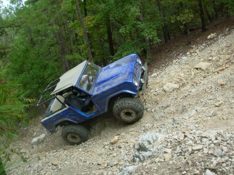 1983 Ford Bronco - This blue 1983 Ford Bronco navigates a challenging rocky trail, its off-road capabilities.
