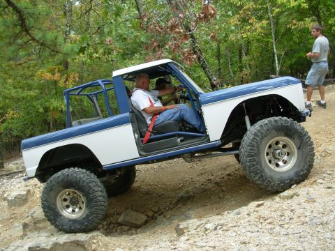 1983 Ford Bronco - This heavily modified SUV navigates a challenging off-road course with its occupants.