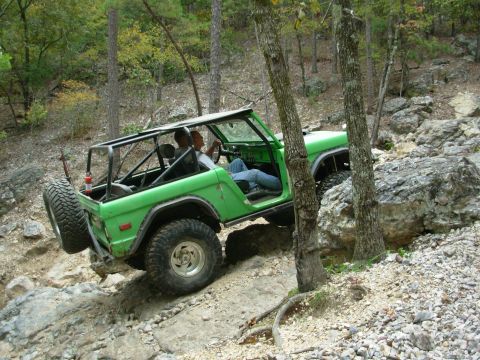 1983 Ford Bronco - This off-road SUV navigates a challenging rocky trail with two occupants inside.