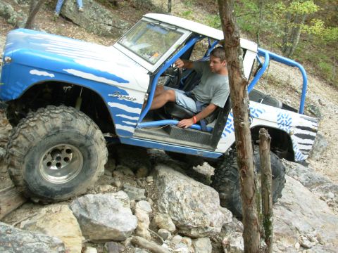 1983 Ford Bronco - This modified Ford Bronco is navigating a rocky trail with a driver behind the wheel.