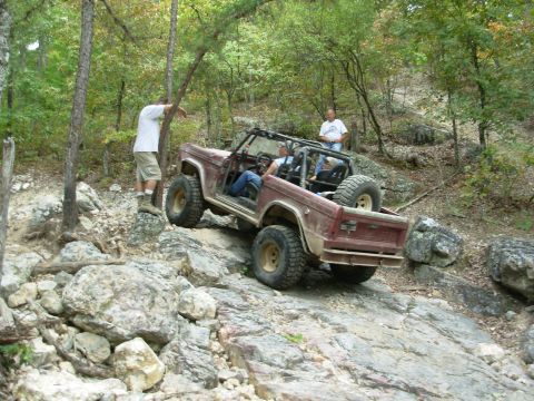 1983 Ford Bronco - This 1983 Ford Bronco navigates a challenging rocky trail with two people inside and another person observing.