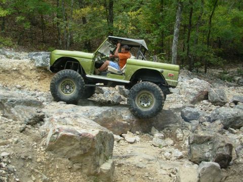1983 Ford Bronco - This modified Ford Bronco navigates a challenging rocky trail with its driver at the wheel.