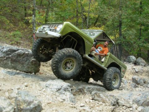 1983 Ford Bronco - This modified off-road vehicle navigates a challenging rocky trail, demonstrating its impressive articulation and ground clearance.