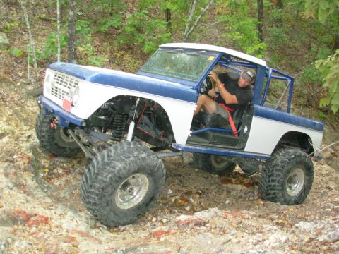1983 Ford Bronco - This modified 1983 Ford Bronco navigates a challenging off-road course with its lifted suspension and oversized tires.