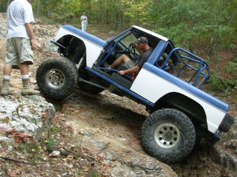 1983 Ford Bronco - Modified 1983 Ford Bronco tackling a steep, rocky trail during an off-road event.