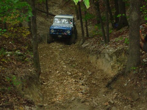 1983 Ford Bronco - Ford Bronco navigates a challenging off-road course through a forest.