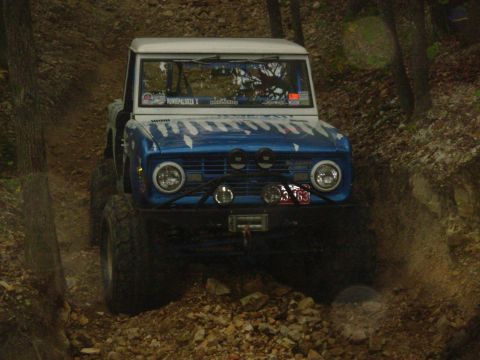 1983 Ford Bronco - This modified Ford Bronco navigates a rocky, wooded path, its off-road capabilities.