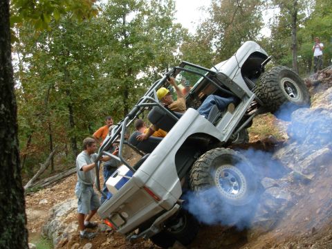 1983 Ford Bronco - Off-road enthusiasts navigate a challenging rocky incline in a modified Ford Bronco.