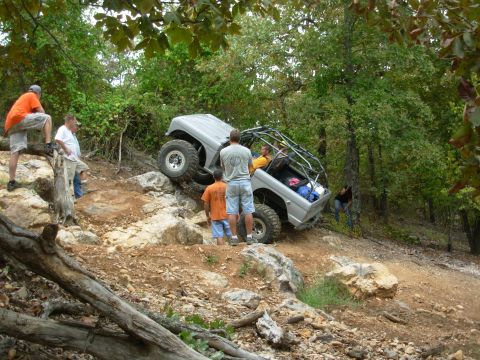 1983 Ford Bronco - Modified 1983 Ford Bronco navigates a challenging rocky trail with spectators present.