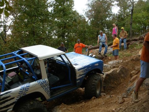 1983 Ford Bronco - A heavily modified 1983 Ford Bronco navigates a challenging off-road course with spectators observing.