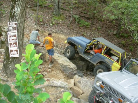 1983 Ford Bronco - Two off-road vehicles, a blue Bronco and a gray Bronco, traverse a challenging rocky path.