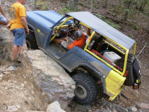 1983 Ford Bronco - This modified 1983 Ford Bronco navigates a challenging rocky terrain with its reinforced roll cage and off-road tires.