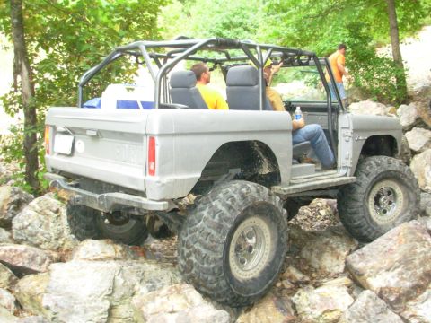 1983 Ford Bronco - This modified SUV navigates a challenging rocky path, its off-road capabilities.