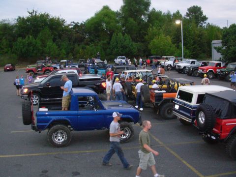 1983 Ford Bronco - A blue Ford Bronco is parked among other vehicles at an outdoor gathering.