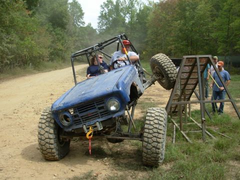 1983 Ford Bronco - Custom off-road vehicle navigating a challenging obstacle course with spectators watching.