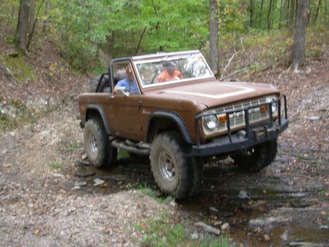 1983 Ford Bronco - This 1983 Ford Bronco navigates a wet, rocky trail through a wooded area.