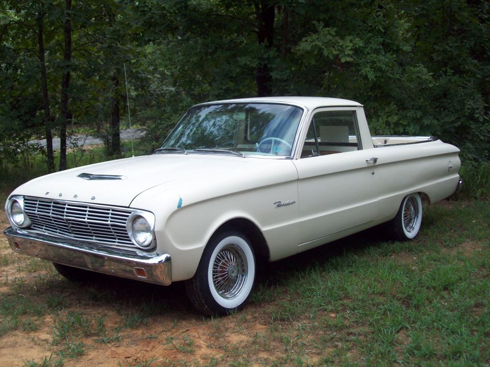Cream Ford Ranchero coupe utility, front three-quarter view on grass with whitewall wire wheels