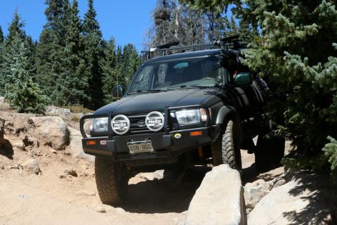 1996 Ford Bronco - This Toyota 4Runner is navigating a rocky trail with trees in the background.