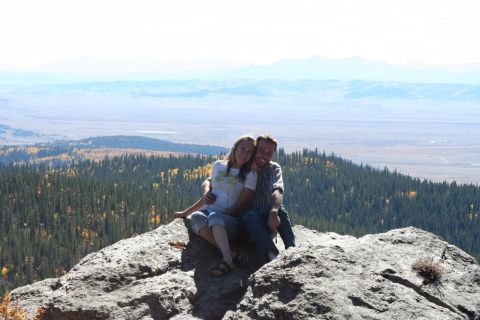 1996 Ford Bronco - A couple enjoys a scenic view from a rocky outcrop in a mountainous region.