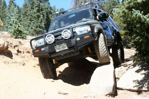 1996 Ford Bronco - This 1996 Toyota 4Runner tackles a challenging off-road trail with its front wheels on rocks.