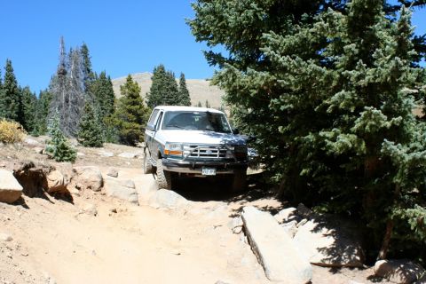1996 Ford Bronco - This 1996 Ford Bronco is shown tackling a challenging off-road path on a sunny day.