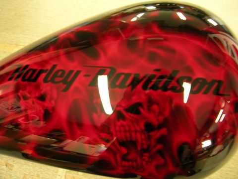 2010 Harley-Davidson Electra Glide - Motorcycle gas tank with custom flame and skull paint job. The Harley-Davidson logo is visible on the side.