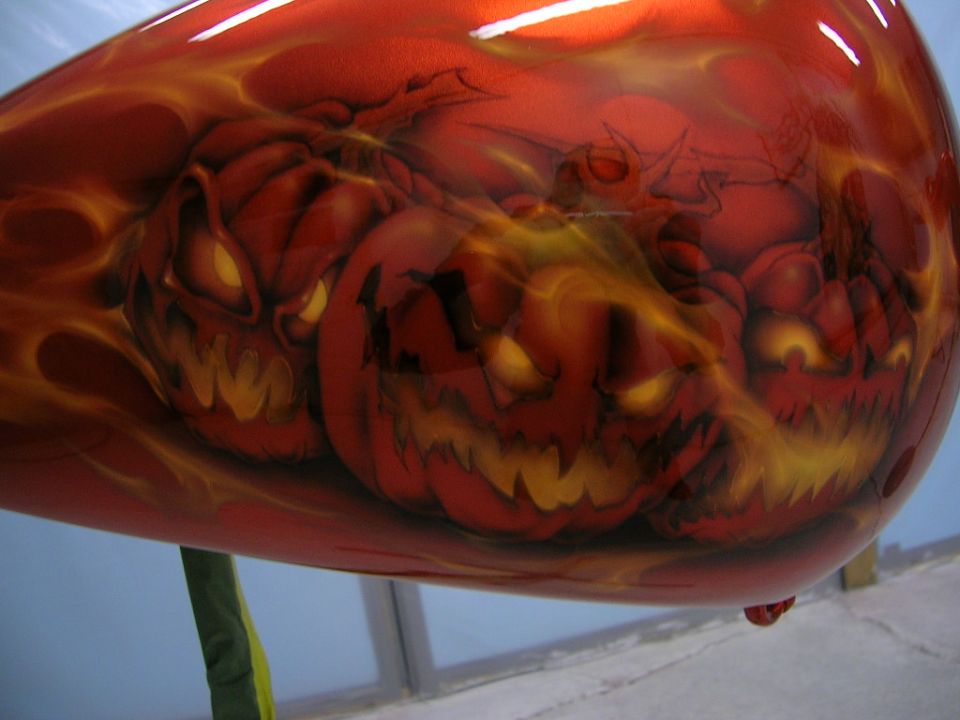 Motorcycle fuel tank with airbrushed jack-o'-lanterns and flames. Red and orange colors