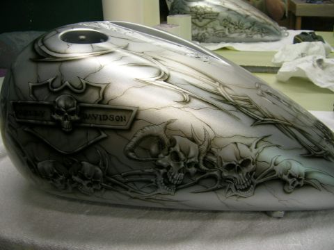 2010 Harley-Davidson Electra Glide - A motorcycle gas tank is airbrushed with a skull and flame design, with a Harley Davidson badge on the side.