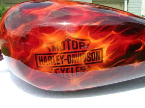 2010 Harley-Davidson Electra Glide - A motorcycle gas tank displays a vibrant flame paint job with the iconic Harley-Davidson logo prominently featured.