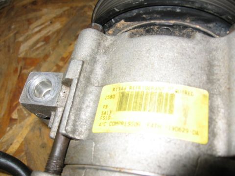 1995 Ford Bronco - AC compressor part with R134a refrigerant label and part number visible.