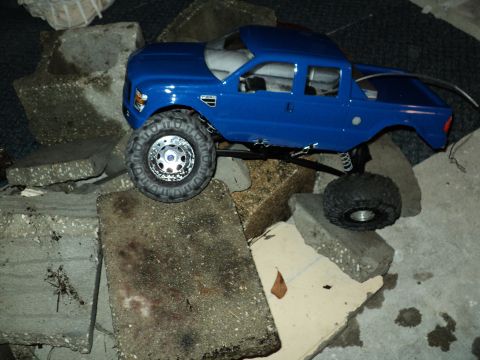2008 Ford F-250 - This blue 2008 Ford F-250 RC truck is positioned on a surface covered with concrete debris.